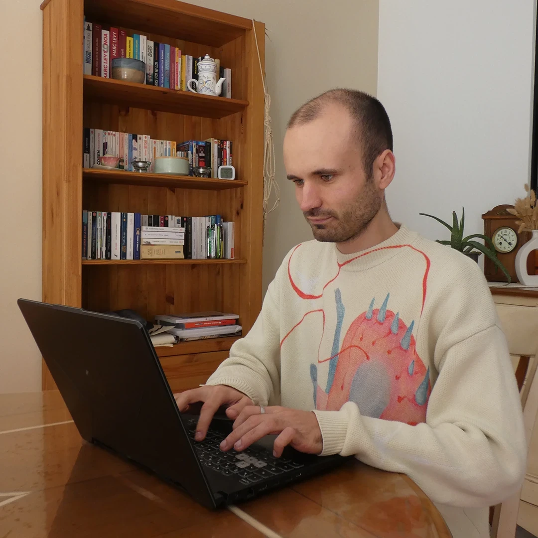 Antoine Koe, développeur web freelance spécialisé WordPress, au travail sur son ordinateur
